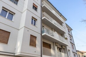 Ein mehrstöckiges Gebäude mit Balkonen, Fenstern und Klimaanlagen.