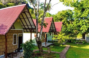 Uma fileira de pequenos edifícios térreos com telhados vermelhos e um jardim bem cuidado.