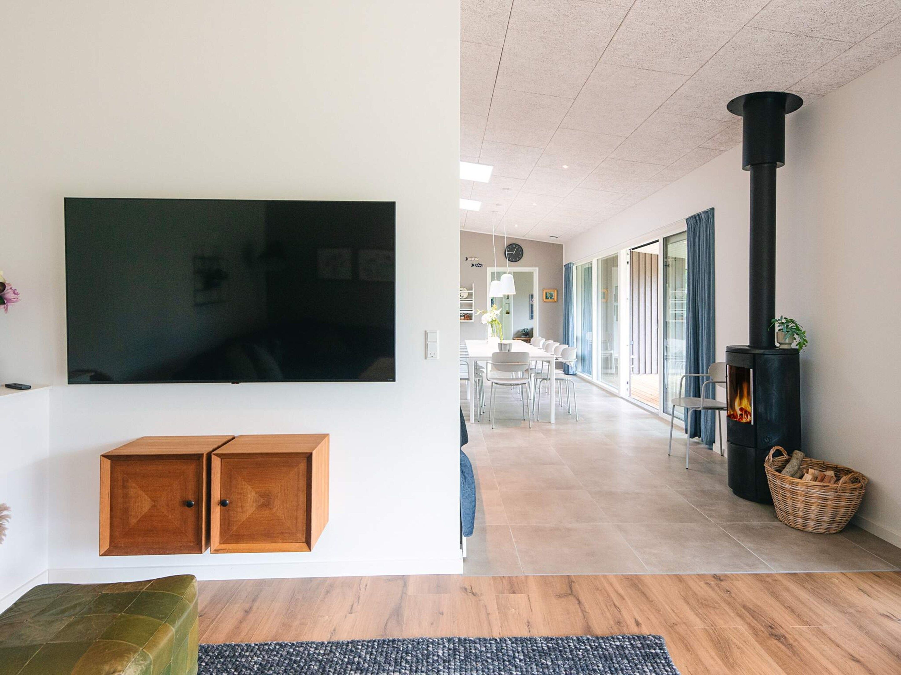 Una sala de estar moderna con un televisor de pantalla plana, un mueble de madera y una chimenea.