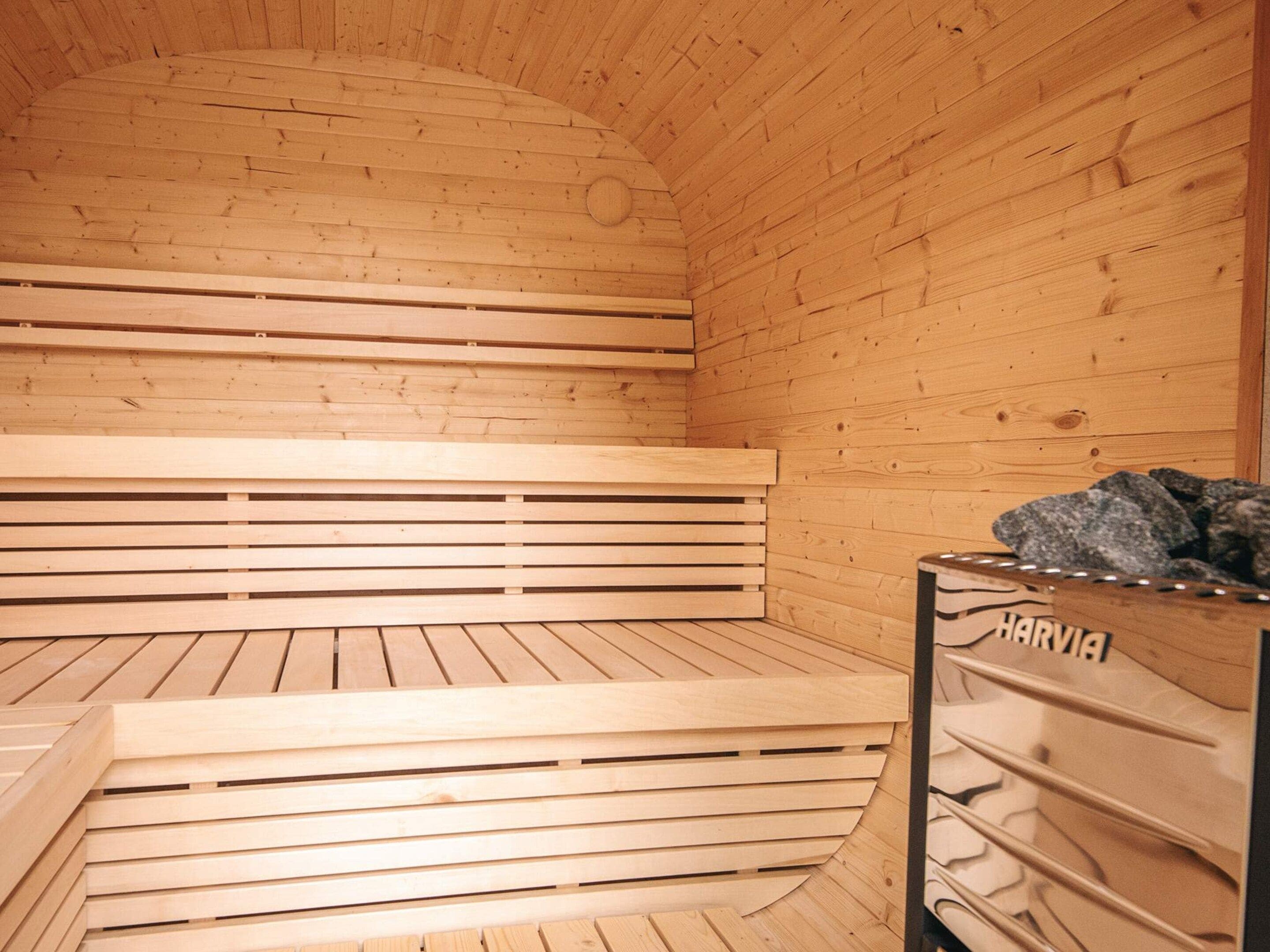A sauna with wooden benches and a stone bench.