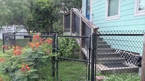 A house with a blue exterior, a fenced yard, and a wooden staircase leading to a door. - Bayside Coastal Retreat Near Copano Bay (Bayside)