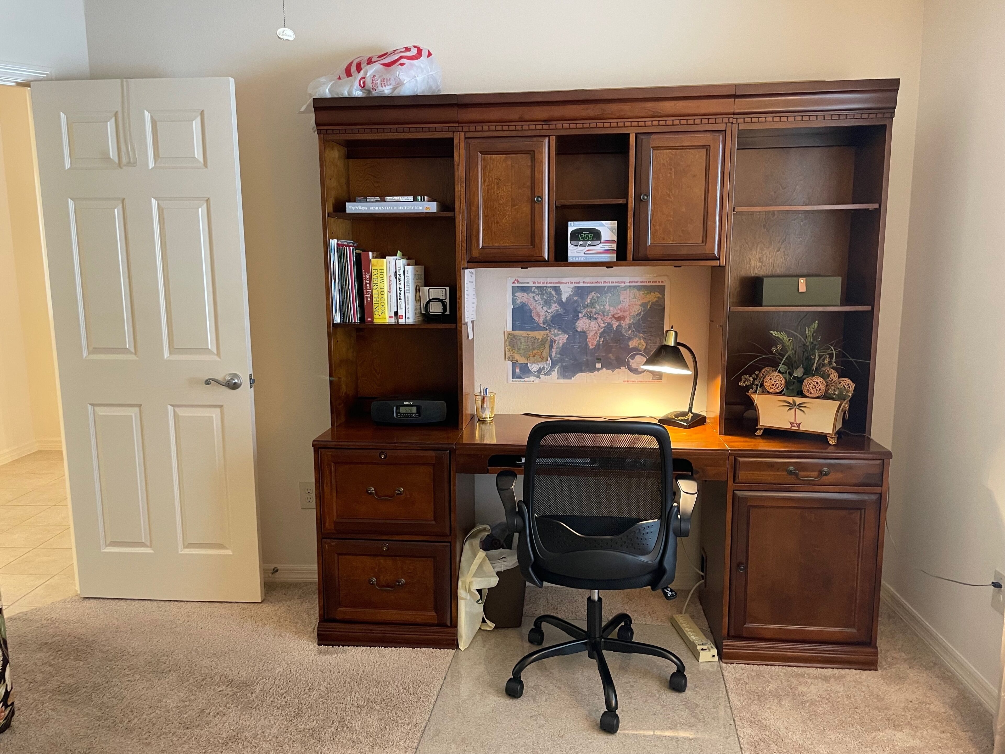 A home office desk with a computer, chair, and various office supplies.