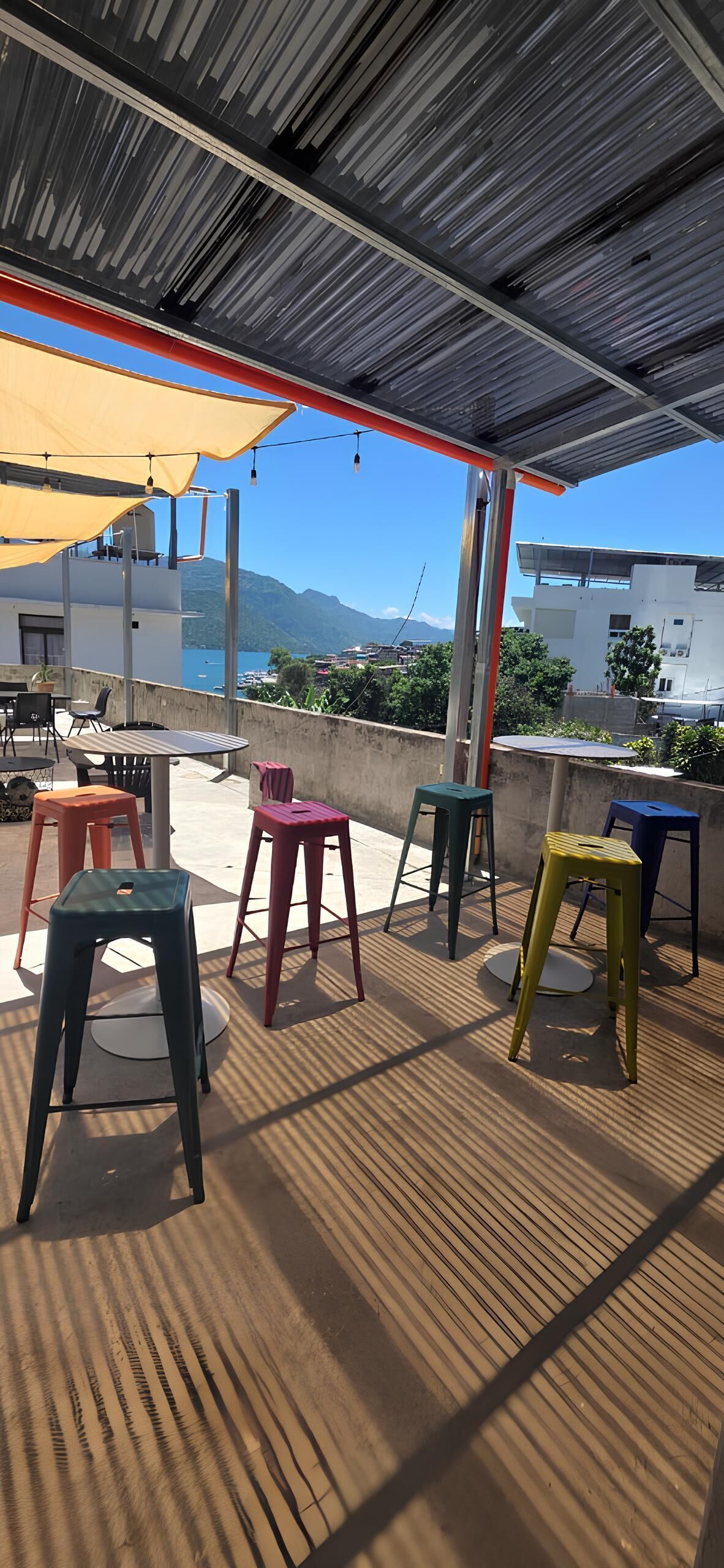 Un área de estar al aire libre con vistas al mar y a las montañas.