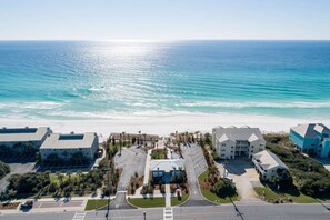 An aerial view of a coastal hotel with a beachfront, parking area, and a central courtyard. - Blue Horizon, Pool, Beach, Golf Cart (Santa Rosa Beach)
