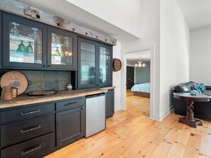 A modern kitchen with dark cabinetry, a dishwasher, and a wooden countertop. - Lakecation on Smith Lake – Where Vacation Memories Begin! (Crane Hill)
