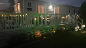 Un edificio residencial con porche, escalera y cerca.
