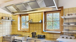 Una cucina con elettrodomestici in acciaio inossidabile, una finestra con vista e uno schienale piastrellato.