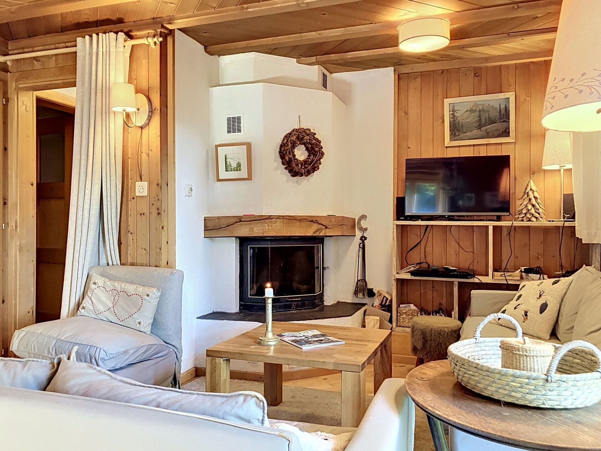 Ein gemütliches Wohnzimmer mit Kamin, Holzwänden, einem Fernseher und einer komfortablen Sitzecke.