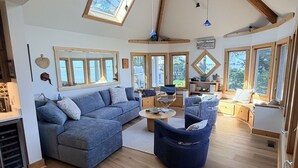 Ein großzügiger Wohnbereich im Loft-Stil mit hohen Decken, großen Fenstern und verschiedenen Sitzgelegenheiten.