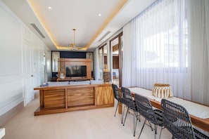 A modern kitchen with a central island, dining area with chairs, and large windows with curtains. - Elegance - Jungle meet with private pool (heated) (La Cruz de Huanacaxtle)