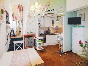 Una cucina con un forno a microonde, lavello e un orologio appeso al muro.