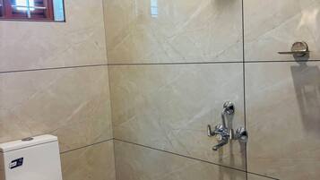 A bathroom with a toilet, a shower, and a window.