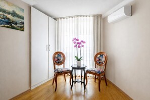 A room with two chairs, a small table, a potted plant, and a painting on the wall. - My Way Teras Hotel (Adalar)