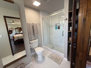 A bathroom with a toilet, shower, and a glass-enclosed shower stall. - FarmStay HillTop wine country views 4BR/4BA (Paso Robles)