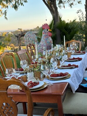 An outdoor dining table set with glassware, plates, and candles, surrounded by chairs. - FarmStay HillTop wine country views 4BR/4BA (Paso Robles)