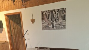 En hyggelig stue med en brun hjørnesofa, et rundt træbord og et indrammet fotografi på væggen.