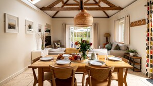 A dining area with a wooden table, chairs, and a hanging light fixture.