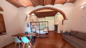 A spacious living area with a dining table, chairs, a sofa, and a fireplace. - An authentic corner of Tuscany. Relaxation, good food, close to Florence, Siena, Pisa (Toscana)