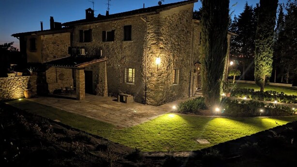 A stone building with a paved entrance, a small outdoor seating area, and a well-lit garden. - An authentic corner of Tuscany. Relaxation, good food, close to Florence, Siena, Pisa (Toscana)