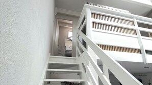 Un escalier blanc avec une rampe menant à l’étage supérieur.
