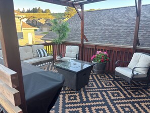 A covered patio with a sofa, chairs, a table, and a potted plant. - Spacious 4-bedroom house in excellent Sturgis with AC (Sturgis)