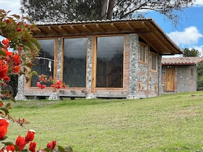 A stone and wood house with large windows and a covered porch.