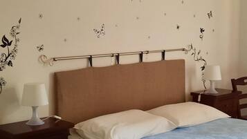 Una camera da letto con un letto, due comodini, una testiera e decorazioni a parete.