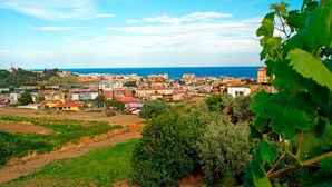Un pueblo costero con edificios, zonas verdes y vista al mar.