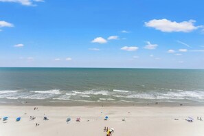 Ein Strand mit Menschen und Sonnenschirmen.