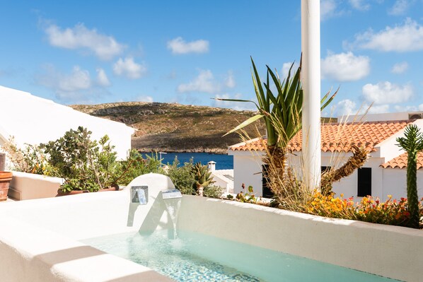 Un espace piscine offrant une vue dégagée sur la mer et un paysage montagneux en arrière-plan.