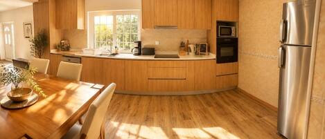 Une cuisine moderne avec des meubles en bois, un réfrigérateur en acier inoxydable et un four encastré.