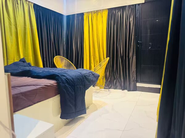 Ein Schlafzimmer mit einem Bett, einem Sessel und VorhÀngen.