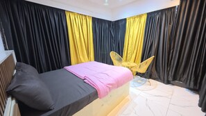 Un dormitorio con una cama, una silla y cortinas.