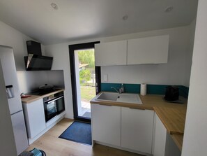 Eine moderne Küche mit eingebautem Backofen, Spüle und Herd.