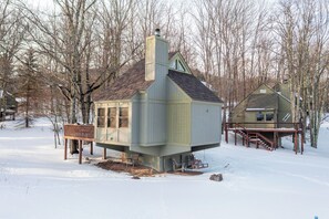 A house with a chimney, a deck, and a snow-covered yard. - Cozy Cabin in Black Bear (Davis)