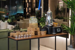 A modern living room with a coffee station, a decorative lamp, and a view of the city at night. - Jawharat Al Nafel Serviced Apartments (Riyadh)