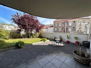 A terrace with a tiled floor, potted plants, and a table with chairs. - Le millésime Vesle | Hypercentre | 6 couchages (Reims)
