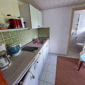 A compact kitchen with a sink, a kettle, and a stove. - Bungalow in Saxon Switzerland (Sebnitz)