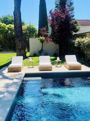 Ein Poolbereich mit Liegestühlen und freiem Blick auf den Pool.