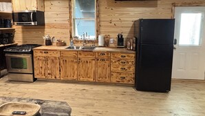 A wooden interior with a kitchen area including a stove, sink, cabinets, and a refrigerator. - River and Refuge Retreat!!!!Cozy 2-bedroom cottage in delightful Columbia NC (Columbia)