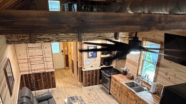 A loft-style living area with a sofa, a coffee table, and a kitchen with a sink and stove. - River and Refuge Retreat!!!!Cozy 2-bedroom cottage in delightful Columbia NC (Columbia)