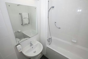 A bathroom with a sink, mirror, toilet, and shower.