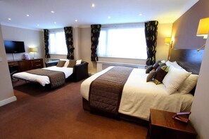 A hotel room with two beds, a flat-screen TV, a desk, and a window with curtains. - Dolphin Sa1 (Swansea)