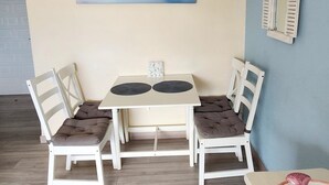 Un comedor con una mesa y sillas, un cuadro en la pared y un espejo.