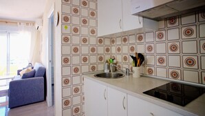 Una cocina con baldosas estampadas, un lavamanos, armarios y una estufa.
