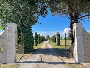 A gravel path leading through a gate with stone pillars and a sign reading 'MAS'. - Mas Dou Rose, farmhouse with swimming pool near Alpilles (Arles)