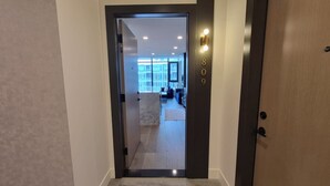 A modern hallway with a door marked '809' leading to a living area with a sofa and a coffee table. - Kelowna Aqua Waterfront Rental (Kelowna)