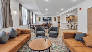 Una sala de estar moderna con dos sofás, una mesa de centro y un comedor con sillas y una mesa.
