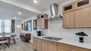 Una cocina moderna con gabinetes de madera, una campana extractora de acero inoxidable y una estufa integrada.