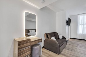 Ein modernes Zimmer mit einem Holzinlay, einem Sofa, einem Fernseher und einem großen Spiegel.